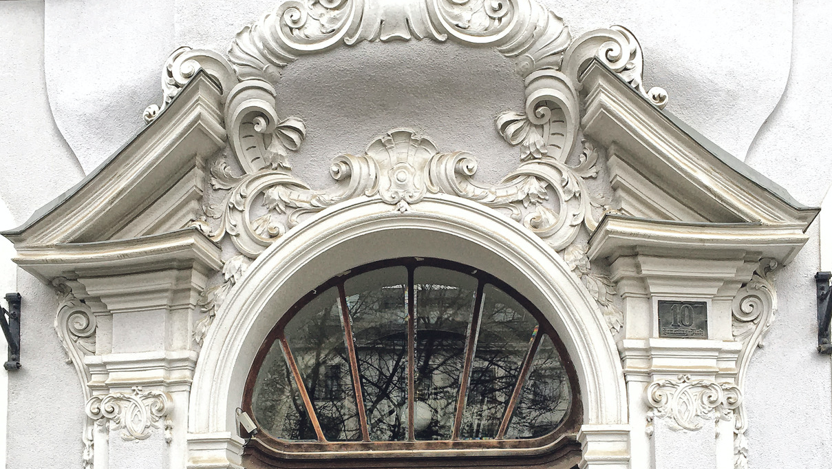 alte Eingangstür aus Eichenholz mit Glas darüber weißer Stuck