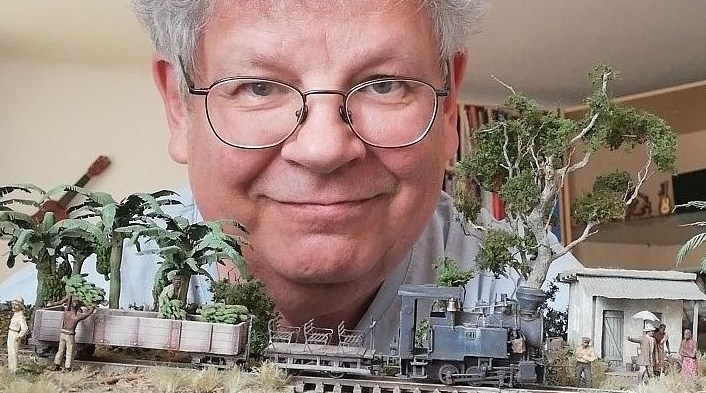 Mann mit Brille vor einem Modellbau-Zug