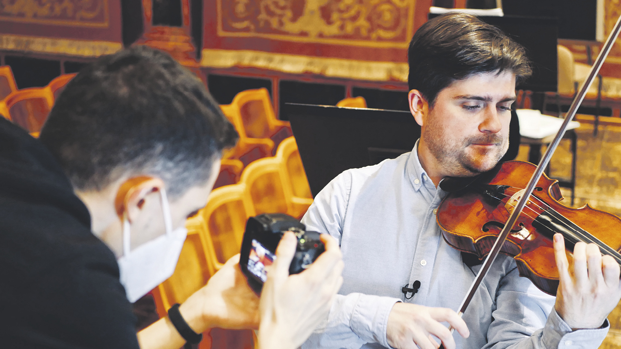 Mann spielt Geige, zweiter Mann fotografiert ihn