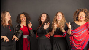 eine gruppe von fünf Frauen mit verschiedenen Nationalitäten, die singen