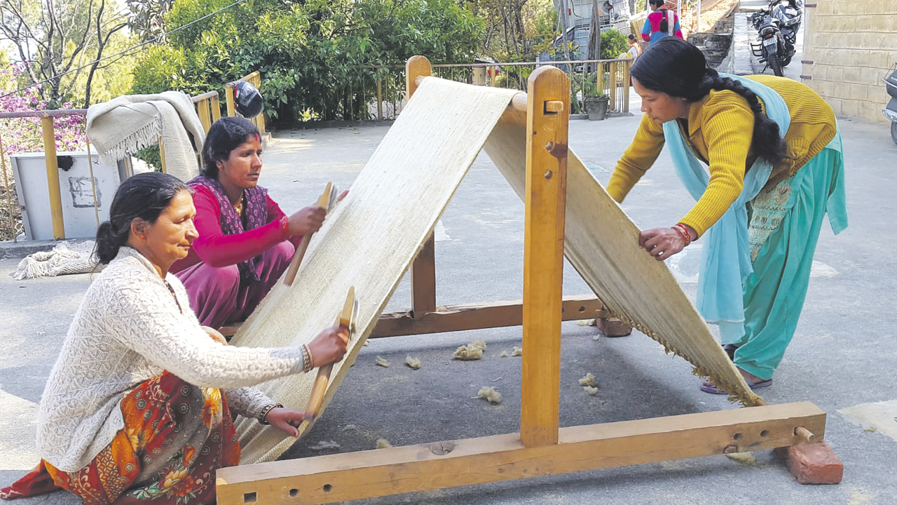 eine Gruppe indischer Frauen beim Weben von Stoffen